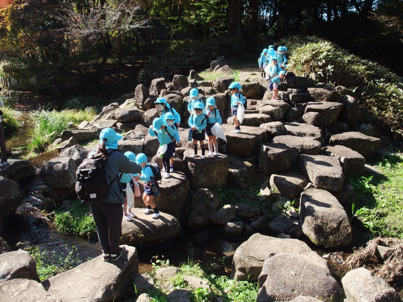 「先生につかまって！」「せ～の！でジャンプして！」大きな石を飛び越えながら反対岸まで渡り切りました。ちょっとした冒険です。