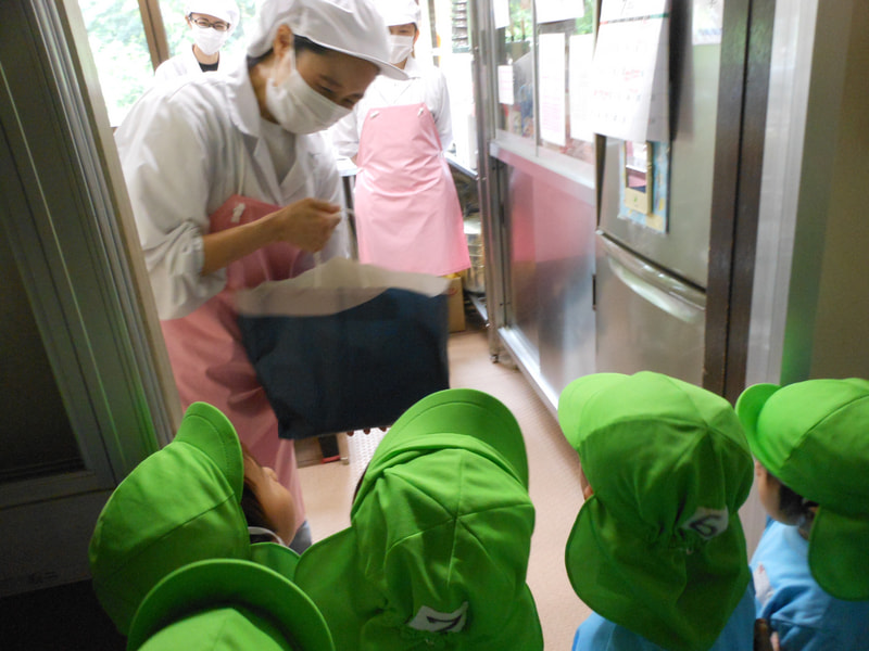 みんなで むいたトウモロコシを、給食室へ。「おいしくしてね」