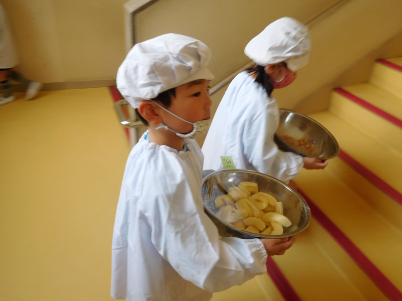 年長さんは給食着を着て給食を運びます。